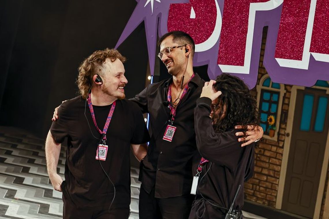 Equipe de stage management de Hairspray nos bastidores, diante do cenário